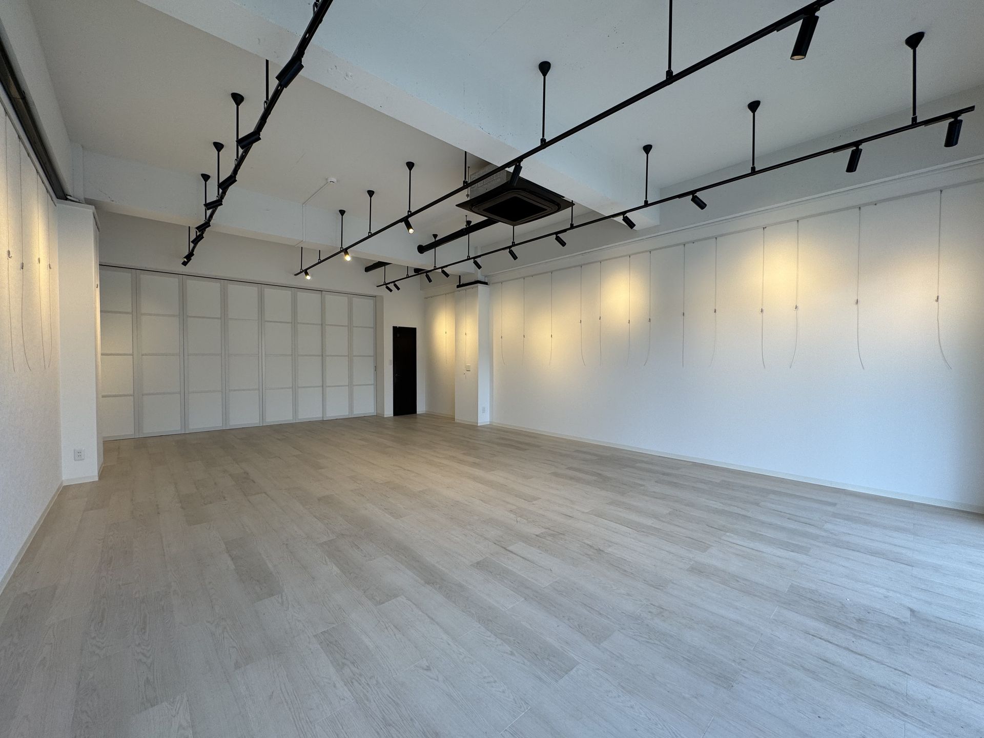 白壁が美しいGallery & Marche ABCの内観。スポットライトが照らす洗練された展示空間